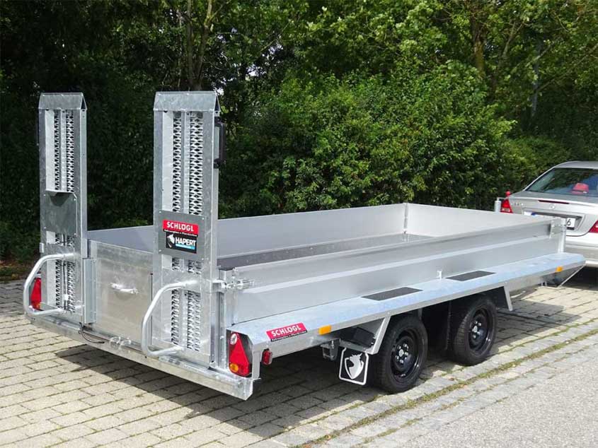 Tandemanhänger mit Rampe und niedriger Bordwand für Fahrzeuge und Baumaschinen.