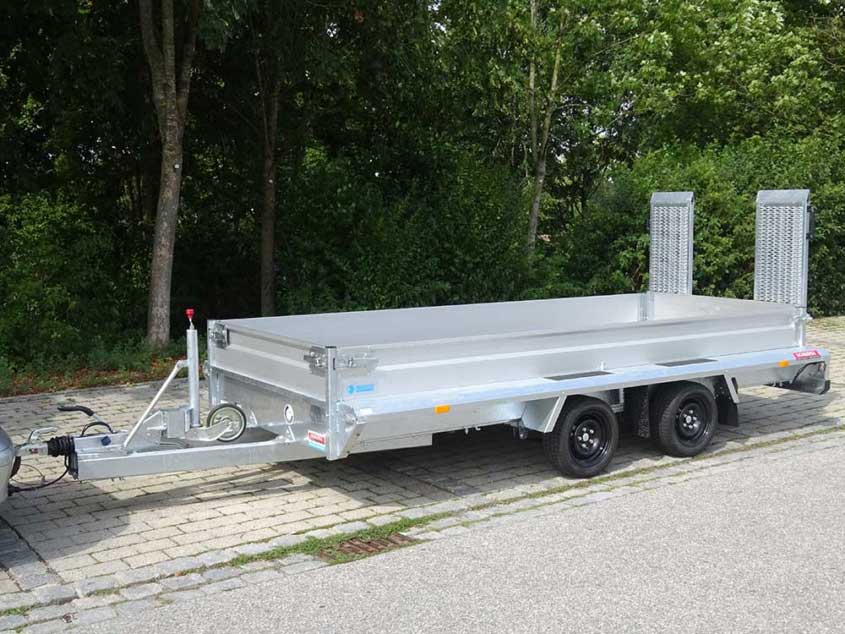 Tandemanhänger mit Rampe und niedriger Bordwand für Fahrzeuge und Baumaschinen.