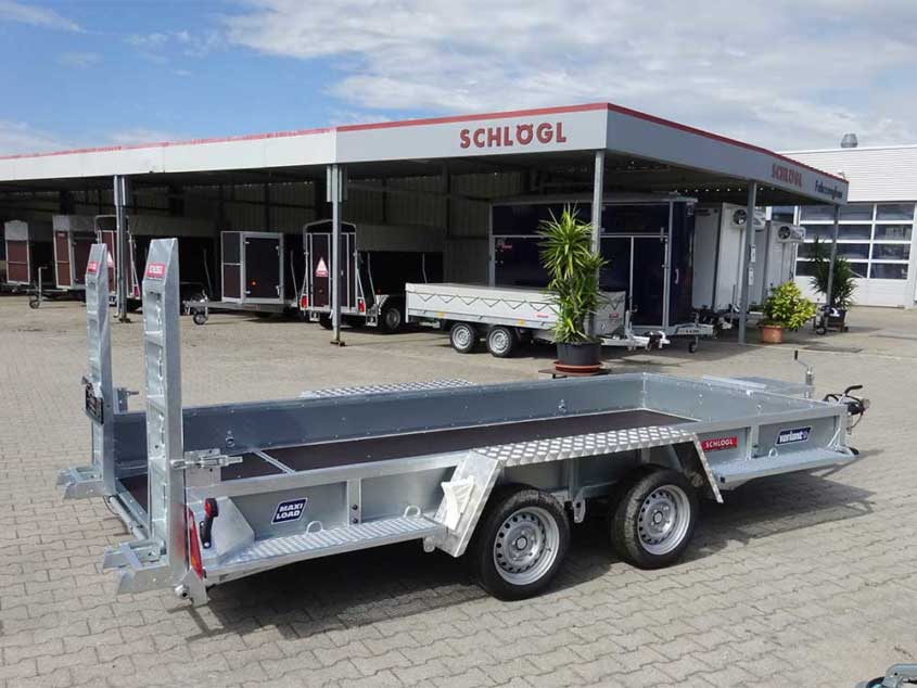 Tandemanhänger mit Rampe und niedriger Bordwand für Fahrzeuge und Baumaschinen.