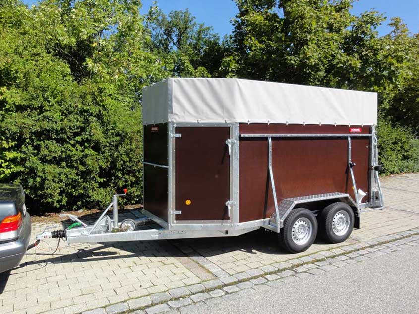 Viehanhänger aus Holz, keilförmig, auf Tandemfahrgestell mit Tür und Planenabdeckung